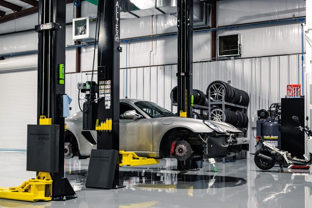 Silver Porsche up on a two-post lift in the shop