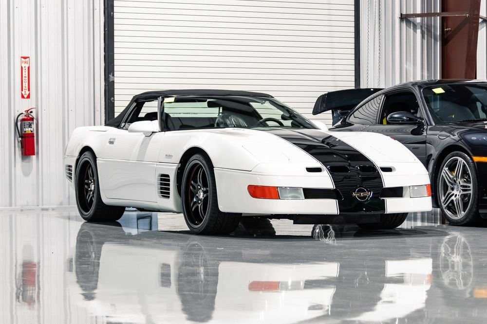 White C4 Corvette with black racing stripes in the shop