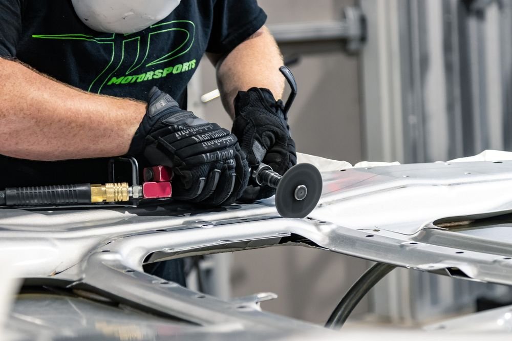 HD Motorsports technician working on a car body panel